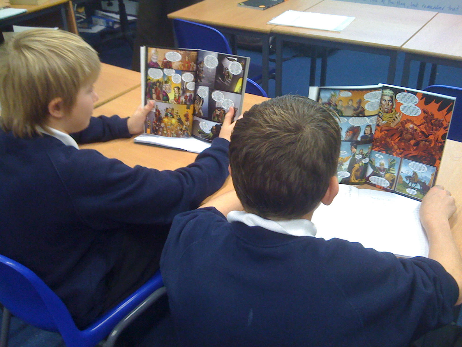 Two schoolboys in class each reading Macbeth: The Graphic Novel